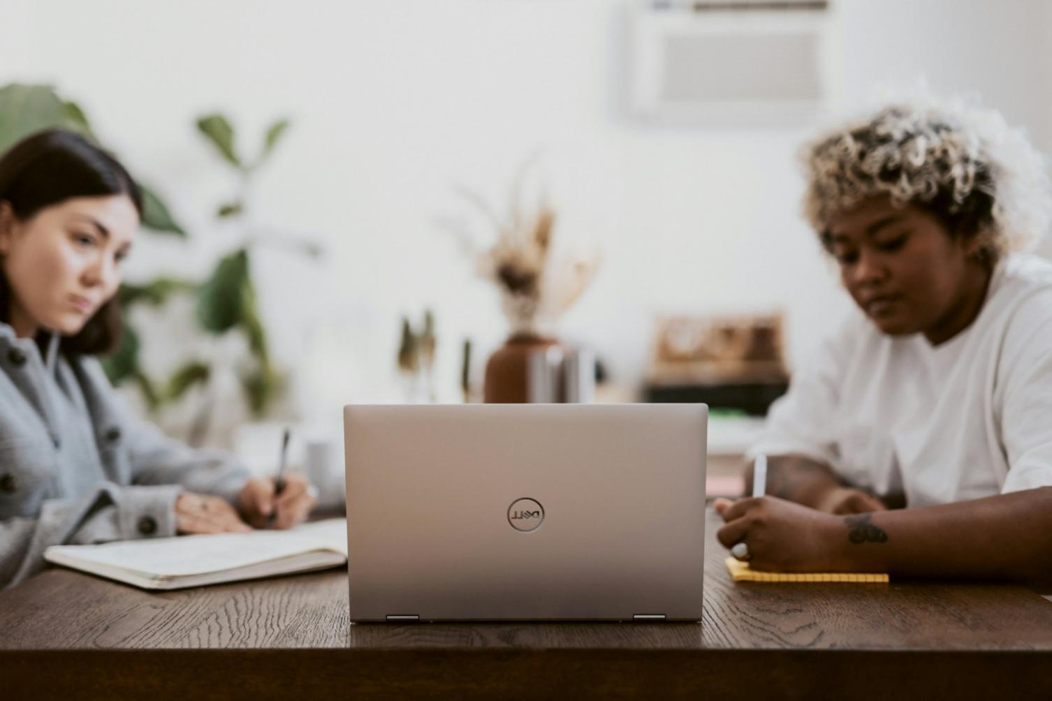 Céline rédigeant des supports de cours entourée de notes et de graphiques d'analyse